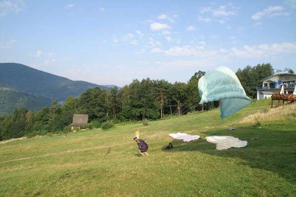 pilot podrywa błękitne skrzydło paralotni